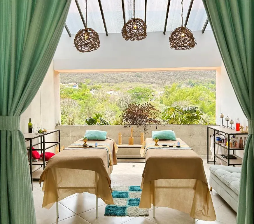 Sala de masajes del spa con dos camillas y cortinas abiertas al paisaje